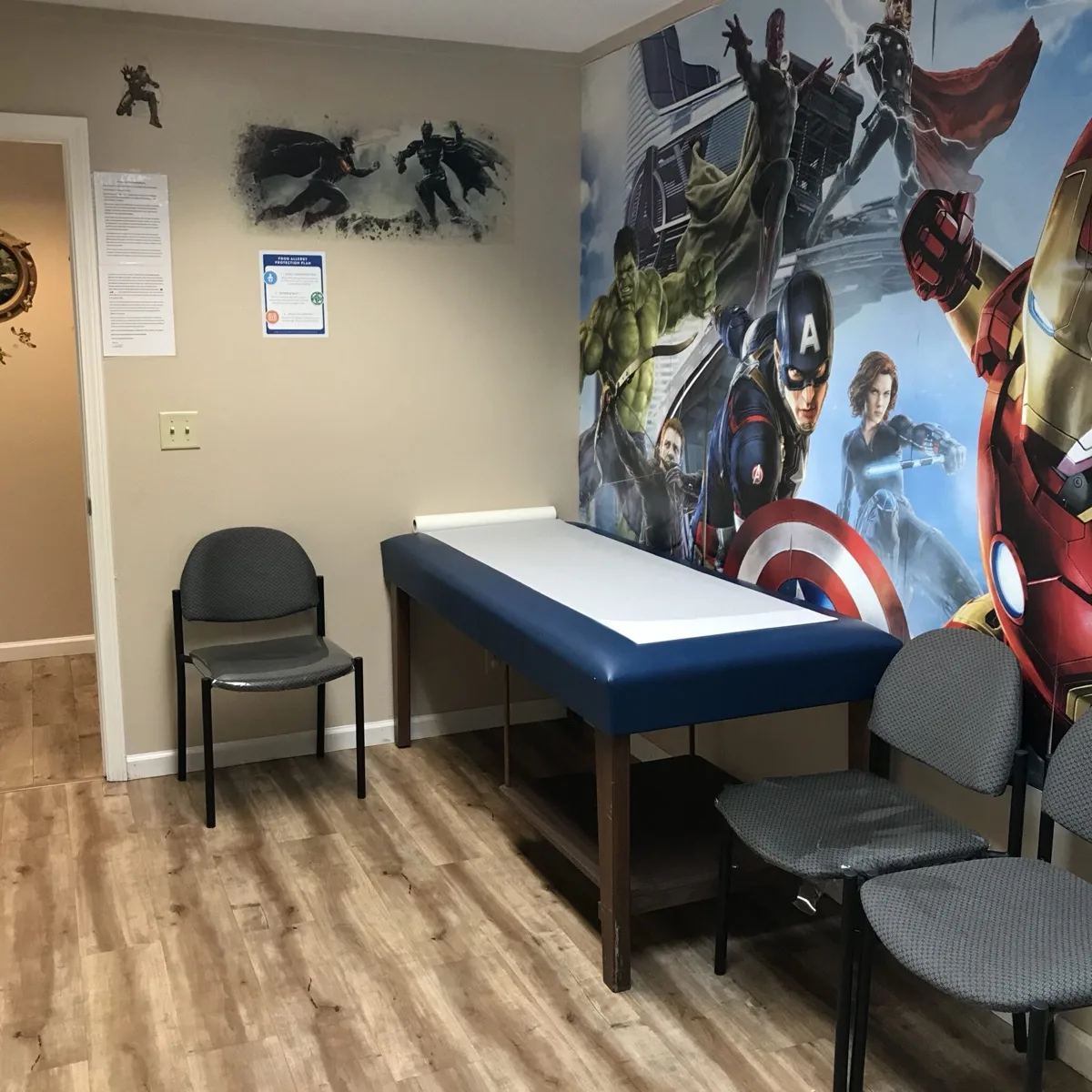 Exam room decorated with a superhero wall mural