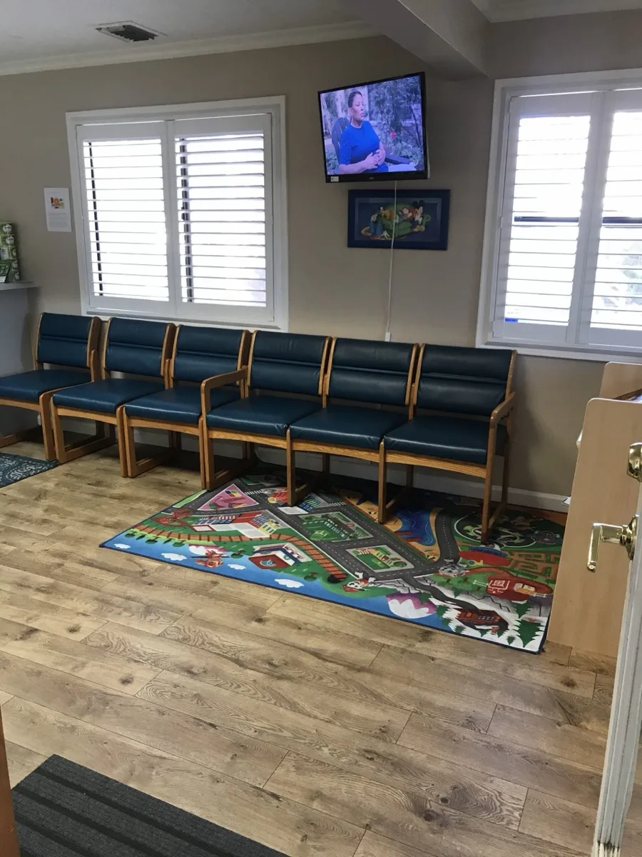 Waiting room corner with a colorful play rug and TV